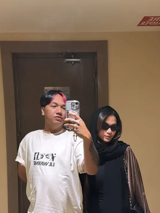 Fitted dress hitam yang dikenakan Azizah dipadukan dengan long satin outer berwarna cokelat tua [@azizahsalsha_]