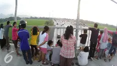 Sejumlah warga melihat suasana arus mudik di Gerbang Tol Palimanan, Cirebon, Jawa Barat (9/7). Rekayasa lalu lintas melalui Lawan Arus menjadi tontonan warga sekitar. (Liputan6.com/Herman Zakharia)