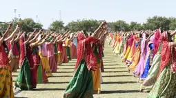 Wanita dari komunitas Shatriya menari dengan pedang dalam upaya untuk menetapkan rekor dunia dalam tarian pedang  di Rajkot,  Ahmedabad, India (28/1/2020). Acara ini bagian dari upacara penobatan tiga hari raja Rajkot ke-17, Thakorsaheb Mandhatasinh Jadeja. (AFP/Sam Panthaky)