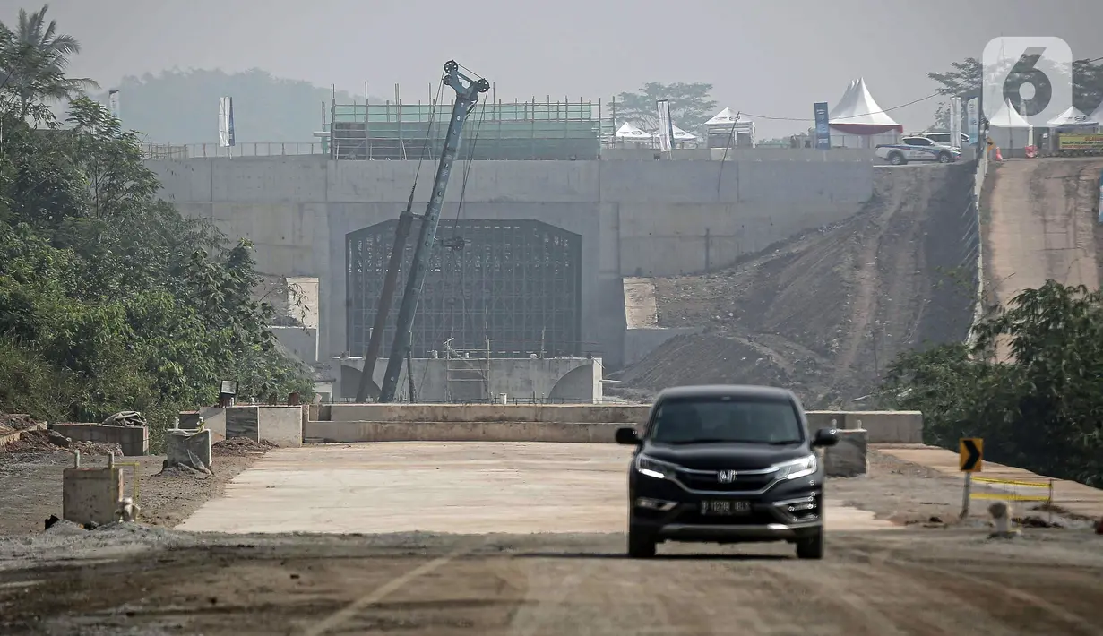 Mobil melintas sekitar proyek Tunnel 6 kereta cepat Jakarta-Bandung di kawasan Cikalong Wetan, Depok, Purwakarta, Jawa Barat, Rabu (30/3/2022). Tunnel 6 memiliki panjang mencapai 4.478 meter yang berada di Cikalong Wetan dekat dengan daerah Walini. (Liputan6.com/Faizal Fanani)