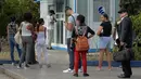 Orang-orang menggunakan ponsel mereka untuk terhubung ke internet melalui WiFi di sebuah taman di Havana, Rabu (5/12). Kuba merupakan salah satu negara terakhir di dunia yang masih belum menerapkan internet mobil. (YAMIL LAGE/AFP)