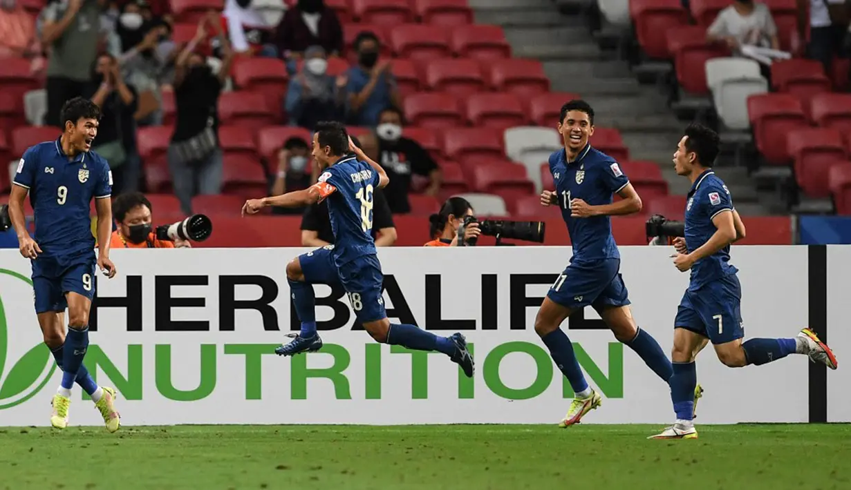 Pemain Thailand Adisak Kraisorn (kiri) merayakan golnya ke gawang Indonesia pada pertandingan sepak bola leg kedua final Piala AFF 2020 di National Stadium, Singapura, Sabtu (1/1/2022). Pertandingan berakhir dengan skor 2-2. (Roslan RAHMAN/AFP)