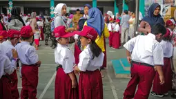 Sejumlah murid bersiap mengikuti upacara bendera pada hari pertama sekolah di SDN Pisangan 02, Ciputat, Tangerang Selatan, Senin (15/7/2019). Senin, 15 Juli 2019 merupakan hari pertama masuk sekolah tahun ajaran 2019/2020 usai libur panjang. (Liputan6.com/Faizal Fanani)