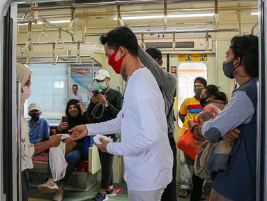 Sekelompok milenial PT KCI bernama C-Ranger membagikan masker kepada para pengguna jasa KRL di Stasiun Tanah Abang, Jakarta, Senin (17/8/2020). PT Kereta Commuter Indonesia (KCI) memperingati Hari Kemerdekaan RI dengan membagikan masker kepada para pengguna jasa KRL. (Liputan6.com/Faizal Fanani)