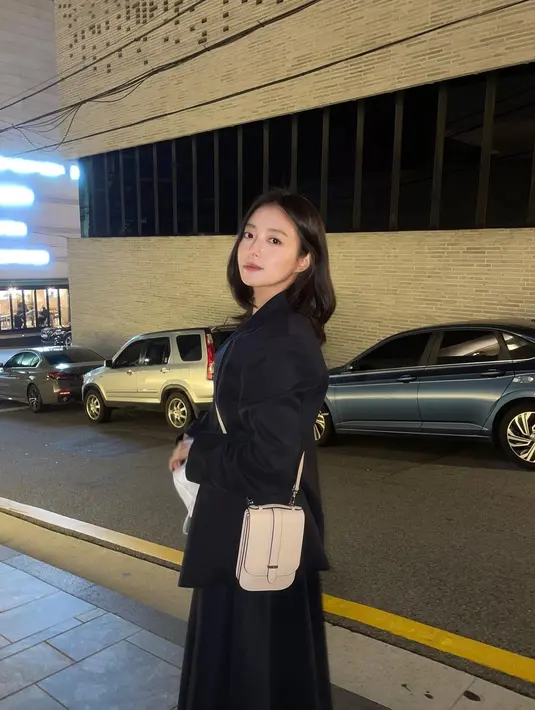 Lee Se Young tampil feminin dengan memadukan tank top dan blazer sebagai atasan. Kemudian menggunakan pleated skirt dan sling bag untuk kesan femininnya. (instagram/seyoung_10)