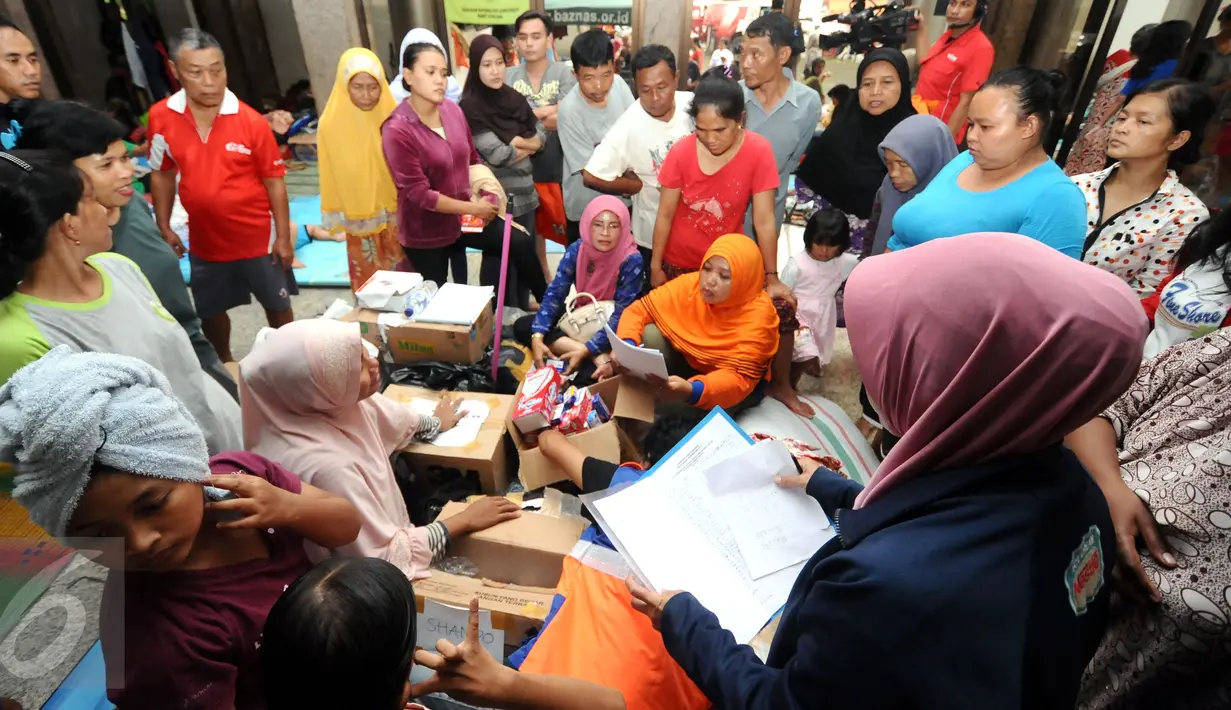 Puluhan warga antri mendapat bantuan alat mandi di dalam Masjid Raya Universitas Borobudur, Jakarta, Senin (20/2). Ratusan warga Cipinang Melayu terpaksa mengungsi akibat banjir yang menggenangi pemukiman mereka. (Liputan6.com/Helmi Fithriansyah)