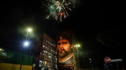 Fans merayakan ulang tahun Diego Maradona dengan kembang api di bawah mural legenda sepak bola itu di Distrik San Giovanni, Napoli, Italia, 30 Oktober 2022. Legenda sepak bola asal Argentina, Diego Armando Maradona yang lahir pada 30 Oktober 1960 meninggal pada 25 November 2020. (Alessandro Garofalo/LaPresse via AP)