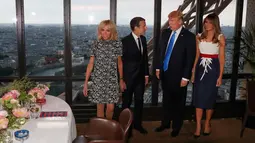 Presiden AS Donald Trump dan Melania Trump serta Presiden Prancis Emmanuel Macron dan Brigitte Macron bersiap untuk jamuan makan malam di Menara Eifel, Paris, Kamis (13/7). Kunjungan Trump ke Paris merupakan undangan Macron (Yves Herman/Pool Photo via AP)