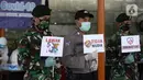 Polisi dan tentara menunjukkan pesan imbauan saat screening test virus corona COVID-19 di Pasar Modern BSD, Tangerang Selatan, Banten, Selasa (21/4/2020). Screening test pendeteksi dini tersebut dilakukan di 12 lokasi di Tangerang Selatan untuk menanggulangi COVID-19. (merdeka.com/Dwi Narwoko)