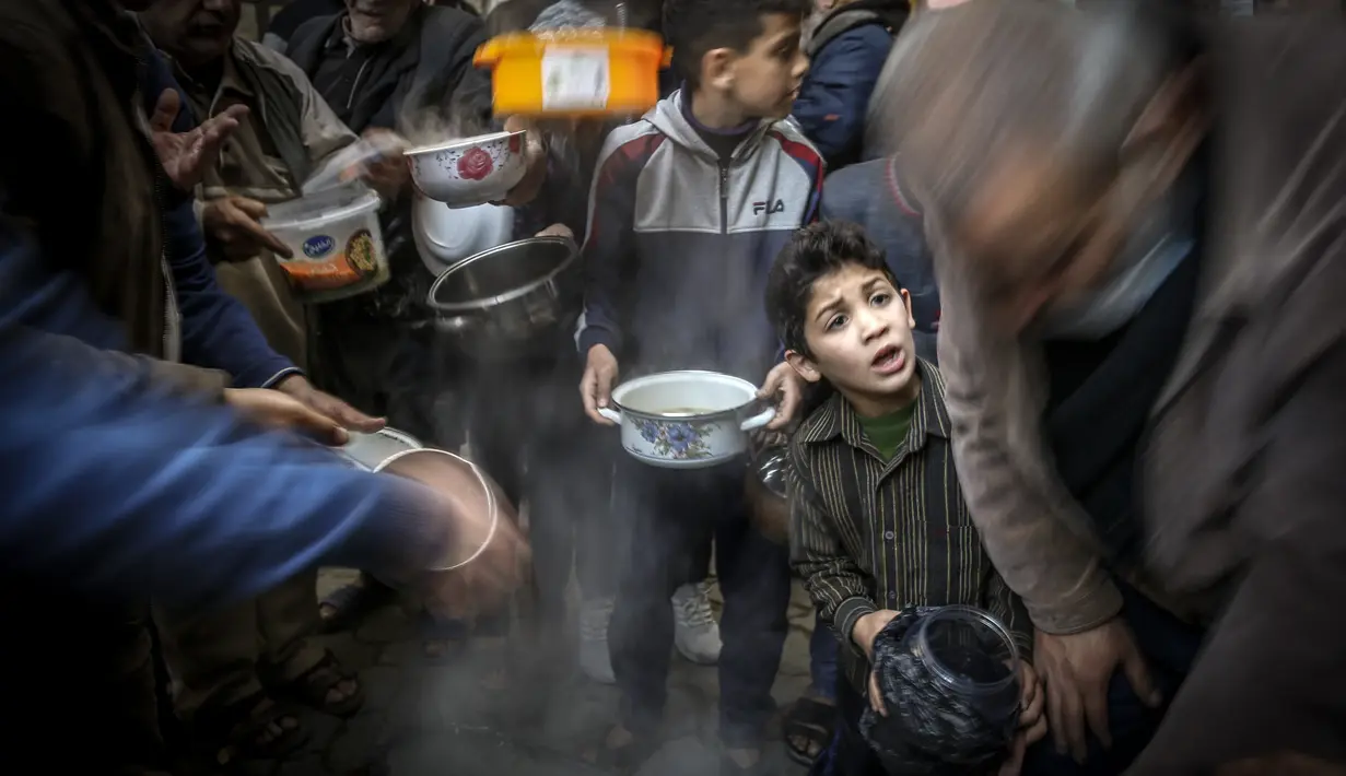 Walid al-Hattab Palestina membagikan sup kepada orang-orang yang membutuhkan selama bulan puasa Ramadhan di tengah pandemi COVID-19 di Kota Gaza (14/4/2021). (AFP/Mohammed Abed)