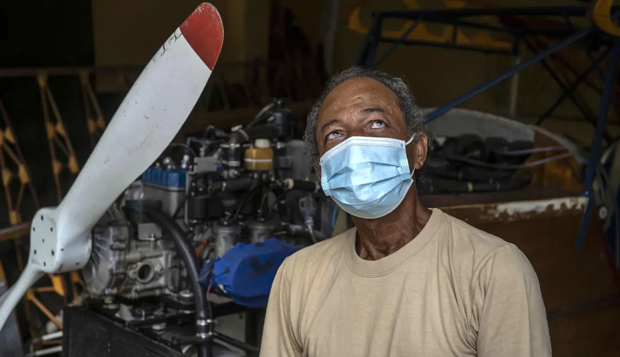 Adolfo Rivera (70) berpose di samping pesawat kayu yang dia buat di garasi gedung apartemennya di Havana, Kuba, 19 Februari 2021. Rivera menerima izin untuk pembuatan pesawat dari Aeronautika Sipil Kuba pada Februari 2012 (AP Photo/Ramon Espinosa)