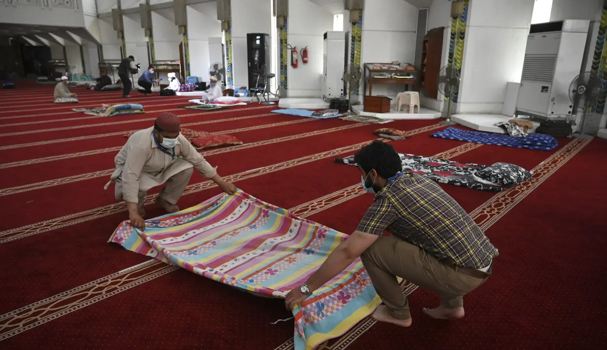 Pria Muslim yang mengenakan masker bersiap untuk duduk di Masjid Agung Faisal pada awal Itikaf, di sebuah masjid untuk pria selama bulan suci Ramadhan di Islamabad (3/5/2021). (AFP/Aamir Qureshi)