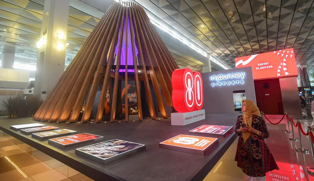 Calon penumpang melihat instalasi arsitektur Nusantara Heritage bertajuk "Tanah Api, Jejak Jiwa” di Terminal 3 Bandara Soekarno-Hatta, Tangerang, Banten, Kamis (14/8/2025). (merdeka.com/Arie Basuki)