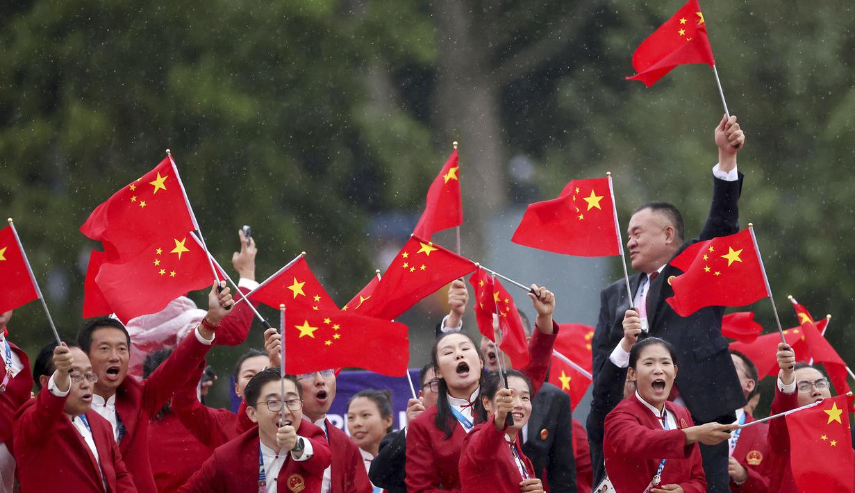 Atlet China mengibarkan bendera saat parade acara pembukaan Olimpiade 2024 di Paris, Sabtu (27/7/2024). (Steph Chambers/Pool Photo via AP)