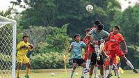 Seorang pemain Timnas Indonesia U-16 berusaha menyundul bola dalam sebuah kemelut di depan gawang SSB Terang Bangsa pada laga uji coba di Lapangan Yogyakarta International School (YIS), Jumat (31/5/2024). (Bola.com/Radifa Arsa)