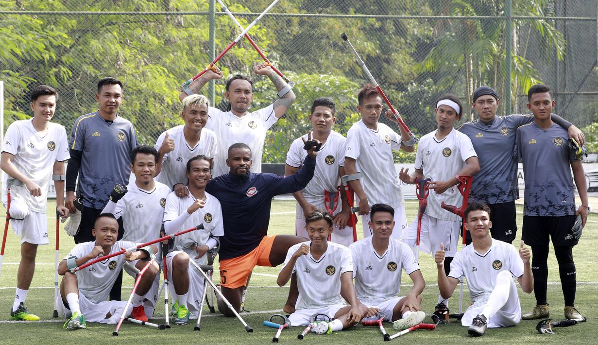 Pemain Timnas Amputasi Indonesia foto bersama dengan Greg Nwokolo usai melakukan latihan di Sports Club Serena Mansion, Jakarta, Selasa (28/6/2022). Latihan tersebut merupakan persiapan jelang berlaga di Piala Dunia Sepakbola Amputasi atau World Amputee Football Federation (WAFF) World Cup 2022 di Turki pada Oktober 2022. (Bola.com/M Iqbal Ichsan)