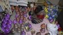 Perajin mewarnai pot minyak tembikar atau diyas menjelang Diwali, festival lampu Hindu, di Hyderabad (4/11/2020). Selama perayaan Diwali, para warga melakukan ritual pembersihan, mulai dari membersihkan dan menghias rumah, berkumpul untuk pesta-pesta khusus. (AFP Photo/Noah Seelam)