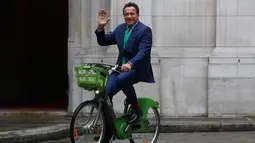 Arnold Schwarzenegger menyapa awak media saat mengendarai sepeda untuk bertemu Walikota Paris, Anne HIdalgo di Paris (11/12). Pertemuan puncak iklim One Planet dihadiri 50 pemimpin dunia dan di-host oleh U.N. dan Bank Dunia. (AP Photo / Thibault Camus)
