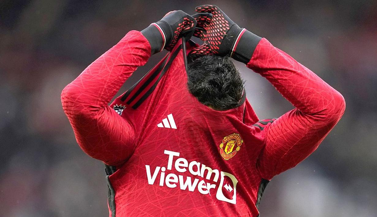 Pemain Manchester United, Casemiro, melepas jersey setelah laga melawan Fulham pada pekan ke-26 Premier League 2023/2024 di Stadion Old Trafford, Sabtu (24/2/2024). MU takluk 1-2. (AP Photo/Dave Thompson)