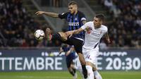 Striker Inter Milan, Mauro Icardi, berebut bola dengan pemain Fiorentina, Nikola Milenkovic, pada laga Serie A Italia di Stadion Giuseppe Meazza, Rabu (26/9/2018). Inter Milan menang 2-1 atas Fiorentina. (AP/Luca Bruno)