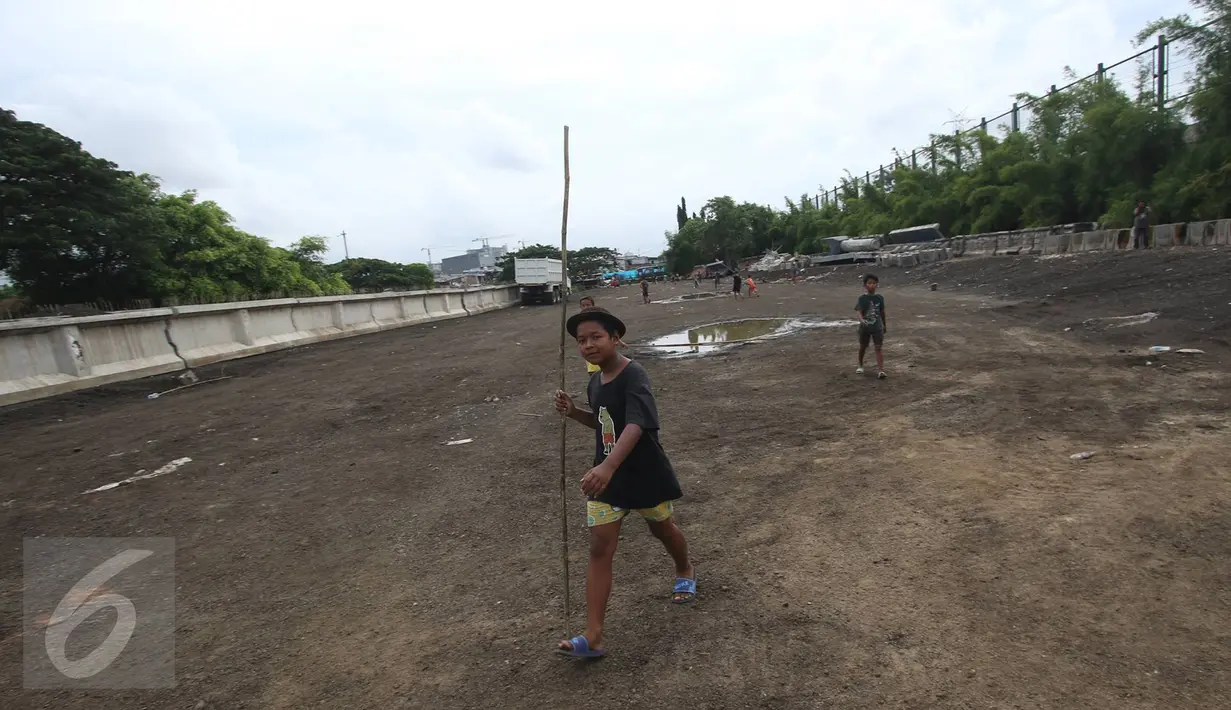 Anak-anak bermain di sekitar pembangunan Taman Bersih Manusiawi dan Wibawa (BMW) di Jakarta Utara, Selasa (7/3). Tempat tersebut akan menjadi markas Persija Jakarta dan Persatuan Sepakbola Seluruh Indonesia (PSSI). (Liputan6.com/Immanuel Antonius)