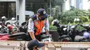 Petugas gabungan yang terdiri dari Satpol PP dan Dinas Perhubungan (Dishub) DKI Jakarta menata motor yang terjaring razia parkir liar di lokasi Citayam Fashion Week, kawasan Stasiun Dukuh Atas, Sudirman, Selasa (26/7/2022). Dishub DKI Jakarta mengamankan sebanyak 16 sepeda motor yang terpakir secara liar. (Liputan6.com/Faizal Fanani)
