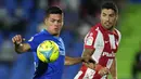 Bek Getafe, Jonathan Silva berebut bola dengan penyerang Atletico Madrid, Luis Suarez pada laga pekan keenam Liga Spanyol di Stadion Coliseum Alfonso Perez, Rabu (22/9/2021) dini hari WIB. Luis Suarez memborong dua gol saat Atletico Madrid mengalahkan Getafe 2-1. (AP Photo/Manu Fernandez)