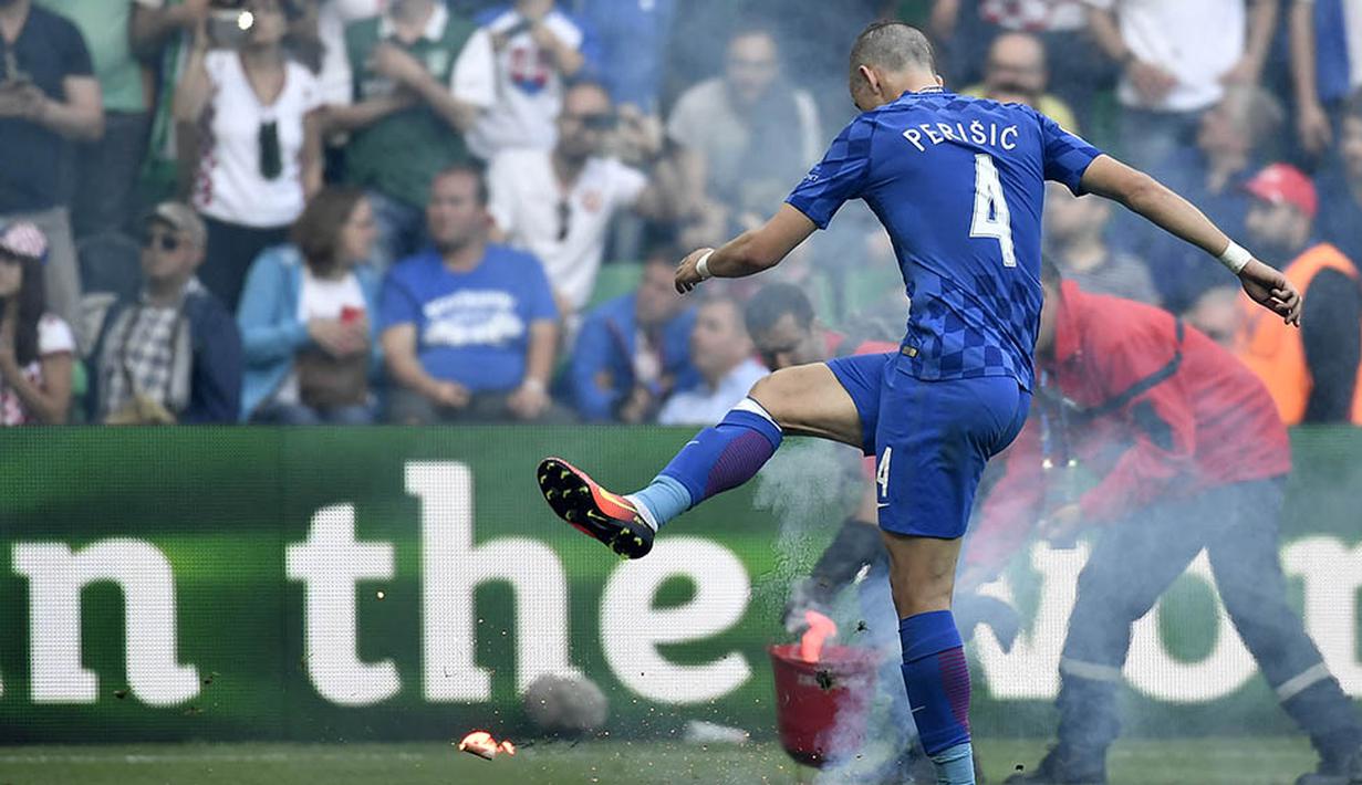 Gelandang Kroasia, Ivan Perisic, menendang suar yang dilempar suporter ke lapangan saat melawan Republik Ceska pada laga Grup D Piala Eropa 2016 di Stadion Geoffrey Guichard, Prancis, Jumat (17/6/2016). (AFP/Jeff Pachoud)