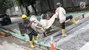 Pekerja menyelesaikan pembetonan Jalan Pejaten Raya di Jakarta Selatan (22/11). Proyek pembetonan dan peninggian badan jalan ini ditargetkan rampung pada akhir November. (Liputan6.com/Immanuel Antonius)