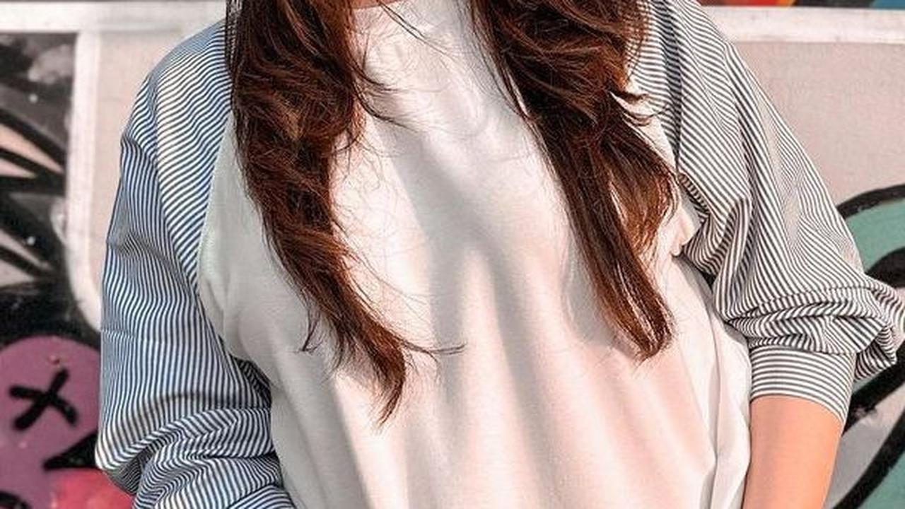 Dalam unggahan lainnya, Nathalie juga telihat kasual dengan tampilan kemeja putih motif garis pada lengan dan celana jeans. Auranya pun terlihat seperti anak muda.