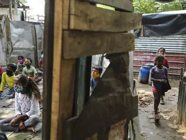 Anak-anak yang mengenakan masker sebagai pencegahan virus corona mengikuti kelas online di sebuah perkampungan kumuh di pinggiran Jammu, India, Senin, 14 Juni 2021. (AP Photo/Channi Anand)