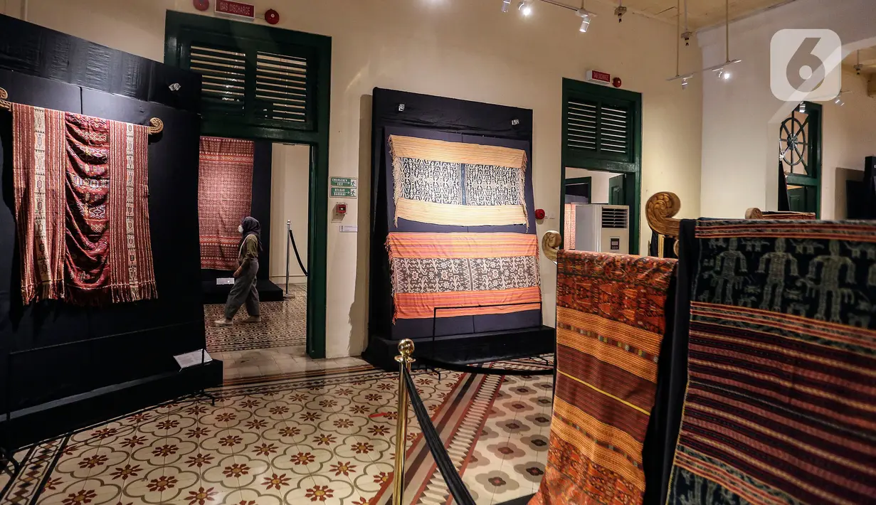 Pengunjung melihat kain tenun di pameran tenun bertajuk "Nuansa Kemilau Wastra Tenun Indonesia" di Museum Tekstil, Jakarta, Rabu (20/7/2022). Pameran dalam rangka memperingati HUT ke - 77 RI ini berlangsung hingga 31 agustus 2022 mendatang dan menampilkan kerajinan tenun dari Sumatera, Sulawesi, dan Timor. (Liputan6.com/Johan Tallo)