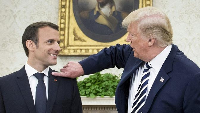 Donald Trump Membersihkan Ketombe di Bahu Presiden Emmanuel Macron (Brendan Smialowski / AFP)