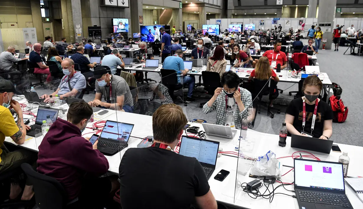 Wartawan beraktivitas di dalam Main Press Center (MPC) Olimpiade Tokyo 2020 di Tokyo pada Kamis (22/7/2021). Main Press Center mulai ramai dengan para jurnalis dari berbagai negara jelang pembukaan Olimpiade Tokyo 2020 pada 23 Juli mendatang. (Martin BERNETTI / AFP)