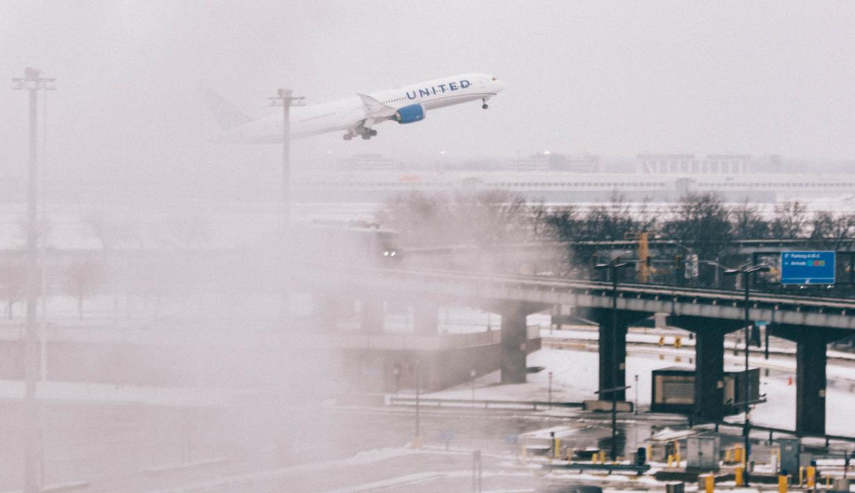 Sebuah pesawat lepas landas saat kondisi badai salju di Bandara O'Hare pada 12 Januari 2024 di Chicago, Illinois. (Jim Vondruska/Getty Images via AFP)
