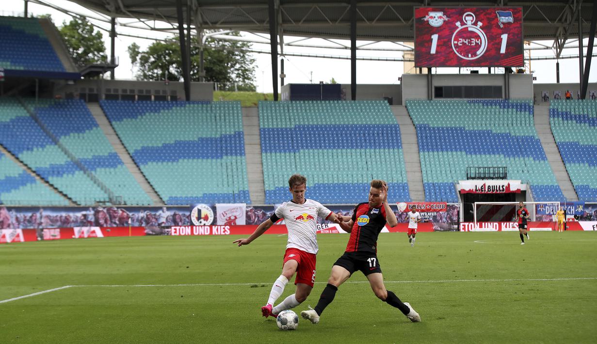 Pemain RB Leipzig, Daniel Carvajal, berebut bola dengan pemain Hertha Berlin, Maximilian Mittelstaedt, pada laga  Bundesliga di Red Bull Arena, Rabu (27/5/2020). Kedua tim bermain imbang 2-2. (AP/Alexander Hassenstein)
