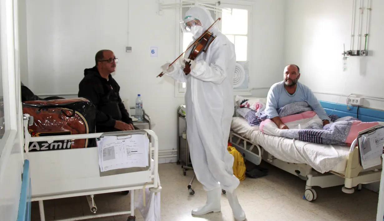 Pasien menikmati permainan biola Dr. Mohamed Salah Siala di bangsal COVID-19 rumah sakit Hedi Chaker di Tunisia, 20 Februari 2021. Ketika pemain 25 tahun itu memutuskan memainkan biolanya, dia mendapat pujian karena meningkatkan semangat pasien yang terisolasi dan membutuhkan senyuman. (AP Photo)