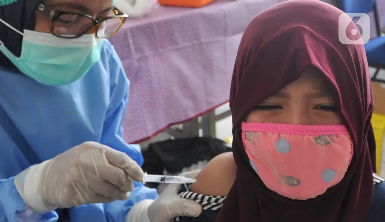 Siswa kelas 1 mendapatkan suntikan vaksin tetanus difteri (TD) di SDI Al Hidayah, Cinere, Depok, Jumat (20/11/2020). Program imunisasi kepada pelajar di Kota Depok terus berjalan guna menjaga kesehatan anak dan meningkatkan imunitas tubuh di masa pandemi COVID-19. (merdeka.com/Arie Basuki)