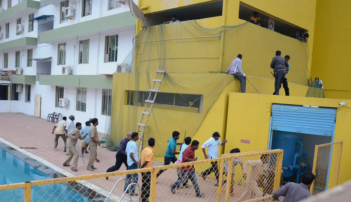 Sejumlah karyawan berlarian akibat seekor macan tutul yang lepas dari kandangnya di sebuah sekolah swasta di pinggiran Bangalore, India, Minggu (7/2). Menurut media setempat, macan tutul tersebut melukai enam orang. (AFP PHOTO/STR)