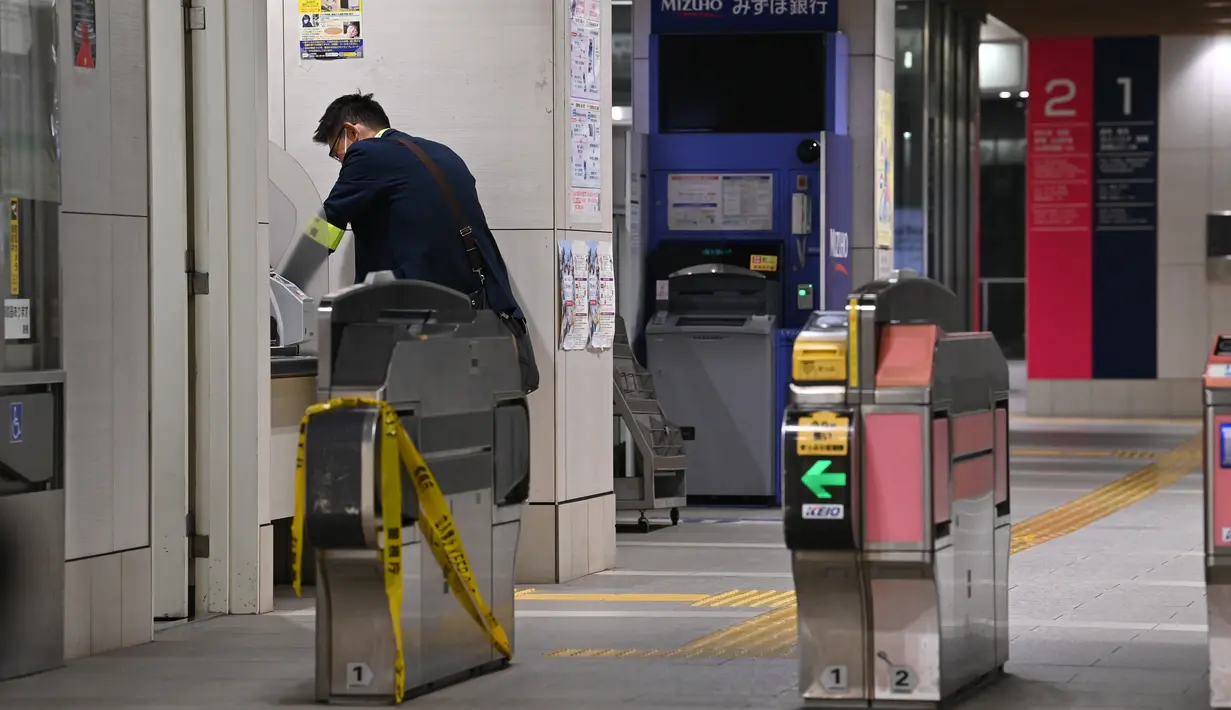 Seorang pejabat berdiri di dekat gerbang tiket Stasiun Kokuryo di Jalur Keio di kota Chofu di Tokyo barat (31/10/2021).  Kepolisian mengatakan pelaku yang bernama Kyota Hattori mengaku suka pada karakter Joker. (AFP/Kazuhiro Nogi)