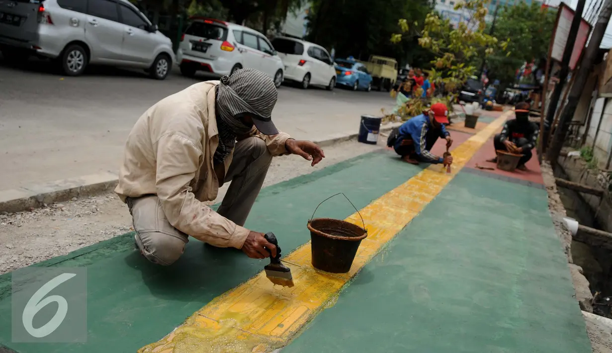 Pekerja menyelesaikan pembangunan Trotoar Ramah Disabilitas di Jalan Hidup Baru, Kalimati, Jakarta Utara, Selasa (27/12). Nantinya trotoar ini akan dibangun sepanjang 753 meter dan lebar 2,4 meter. (Liputan6.com/Gempur M. Surya)