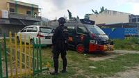 Personel Brimob Polda Sulteng berjaga di salah satu rumah di Kelurahan Silae, Kota Palu yang tengah digeledah Densus 88 Antiteror, Kamis (16/3/2023). (Foto: Heri Susanto/ Liputan6.com).