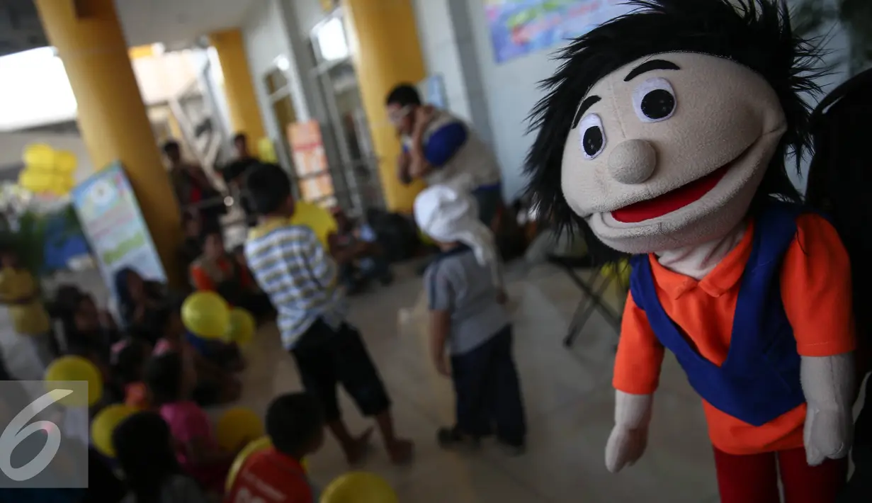 Seorang pendongeng menunjukan boneka untuk menghibur pemudik anak-anak di Pelabuhan Tanjung Priuk, Jakarta, Kamis (30/6). Aksi pendongeng tersebut bertujuan untuk menghibur anak yang turut mudik. (Liputan6.com/Faizal Fanani)