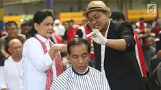 Presiden Joko Widodo disaksikan Ibu Negara Iriana saat mengikuti acara cukur rambut massal di Garut, Jawa Barat, Sabtu (19/1). Jokowi ikut cukur rambut bersama puluhan warga Garut lainnya. (Liputan6.com/Angga Yuniar)