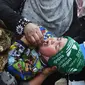 Tenaga kesehatan memberikan vaksin polio kepada seorang balita selama kampanye vaksinasi di kawasan tua Kabul, Afghanistan pada 8 November 2021. Vaksinasi tersebut merupakan yang pertama sejak Taliban berkuasa di Afghanistan. (WAKIL KOHSAR / AFP)