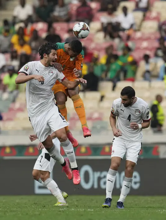 Bek Mesir Ahmed Hegazi melompat saat berebut bola dengan penyerang Pantai Gading Sebastien Haller pada babak 16 besar Piala Afrika 2021 di Stade Omnisport de Douala, Rabu (26/1/2022). Mesir ke perempat final usai menyingkirkan Pantai Gading lewat adu penalti, 5-4 (0-0). (AP Photo/Themba Hadebe)