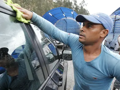 Seorang imigran asal Kuba saat membersihkan sebuah mobil di tempat pencucian mobil, Quito, Ekuador ,Selasa (1/12). Pemerintah Ekuador mengumumkan bahwa warga Kuba yang berada di Ekuador wajib mempunyai Visa. (REUTERS/Guillermo Granja)