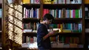 Seorang pria membaca buku di toko buku Lello, Porto, Portugal, Sabtu (12/1). Toko buku Lello ini kini tengah berada di ambang kebangkrutan. (MIGUEL RIOPA/AFP)