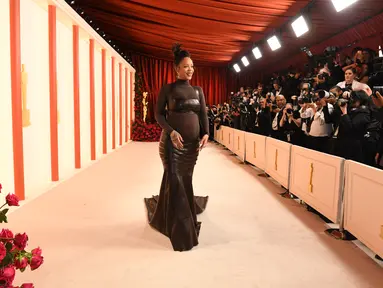 Penyanyi/aktris Barbados Rihanna menghadiri Academy Awards ke-95 atau Oscar 2023 di Teater Dolby di Hollywood, California pada Minggu, 12 Maret 2023, waktu setempat. Pelantun "Where Have You Been" ini berbalut gaun ikat kulit dari Alaïa yang dibuat khusus sembari memamerkan baby bump. (Photo by VALERIE MACON / AFP)