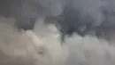 Helikopter militer menjatuhkan air di atas kebakaran hutan di pinggiran Voula, di selatan Athena, Yunani, Sabtu, 4 Juni 2022. Awan asap tebal imbas dari kebakaran hutan itu pun menganggu aktivitas di wilayah pinggiran selatan Yunani. (AP Photo/Yorgos Karahalis)